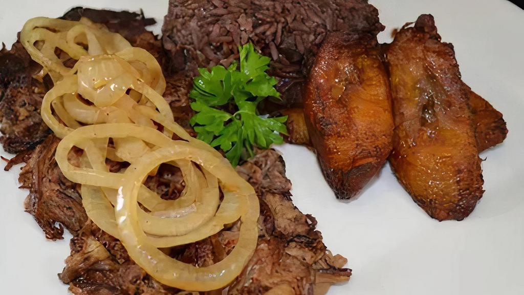 Vaca Frita De Lechon · A flavorful shredded pork grilled to perfection and topped with sauteed onions.