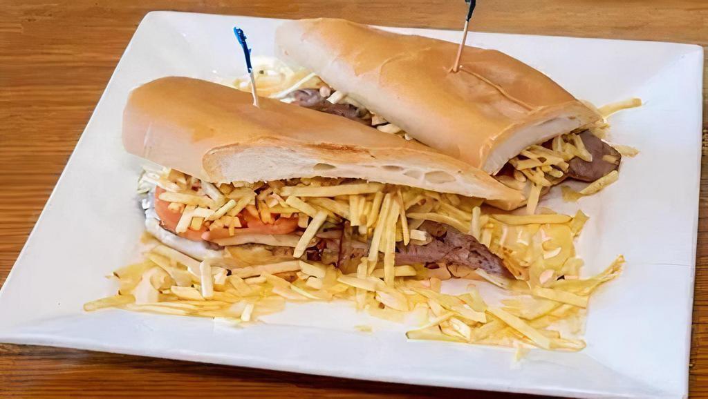 Pan Con Bistec · Our famous steak sandwich on toasted Cuban bread served with grilled with onions and garnished with sliced tomatoes and topped off with julienne fries.