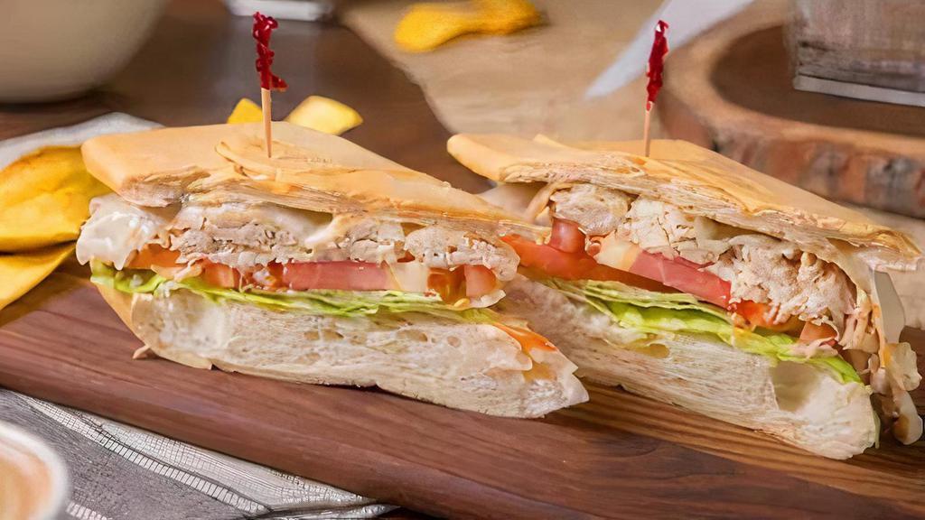 Sandwich De Pollo · Grilled chicken breast, served with lettuce, sliced tomatos and a touch of cilantro garlic aioli sauce on toasted Cuban bread.
