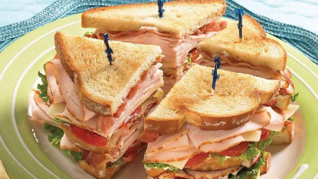 Club Sandwich · Ham, turkey, bacon, swiss cheese, lettuce and tomatoes with a touch of mayo on white toasted bread, served with fries.