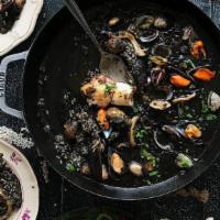 Paella De Arroz Negro · Black rice paella with squid, fish and shrimp