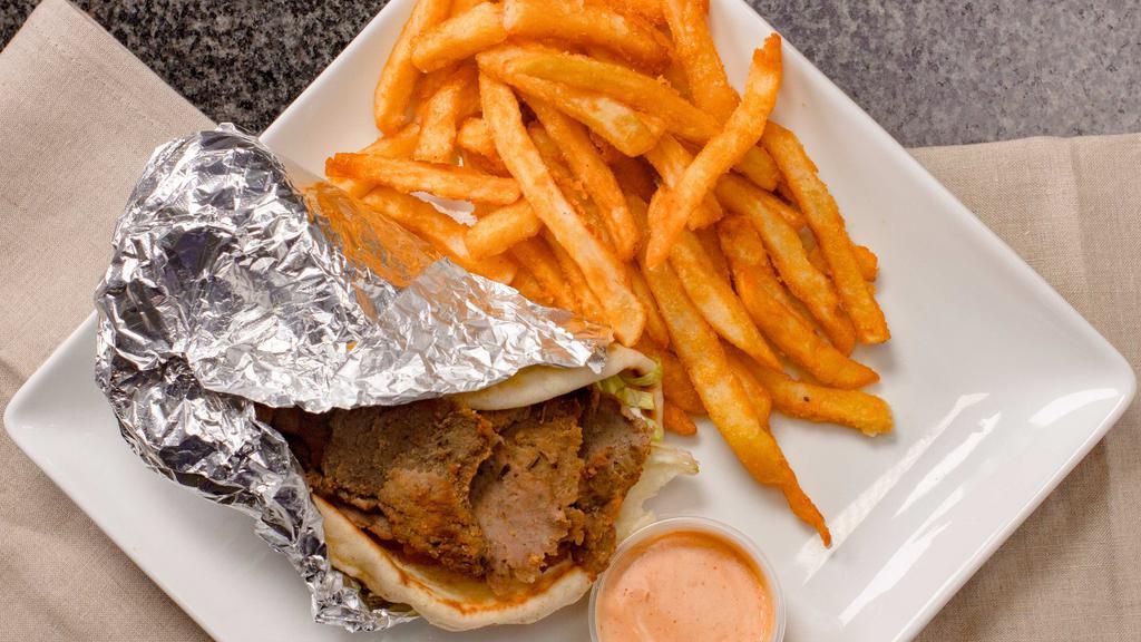 Greek Gyro Sandwich · A blend of seasoned beef and lamb wrapped in a warm pita topped with lettuce, tomato, and tzatziki sauce. Served with choice of our homemade chips, French fries, or baked potato salad.