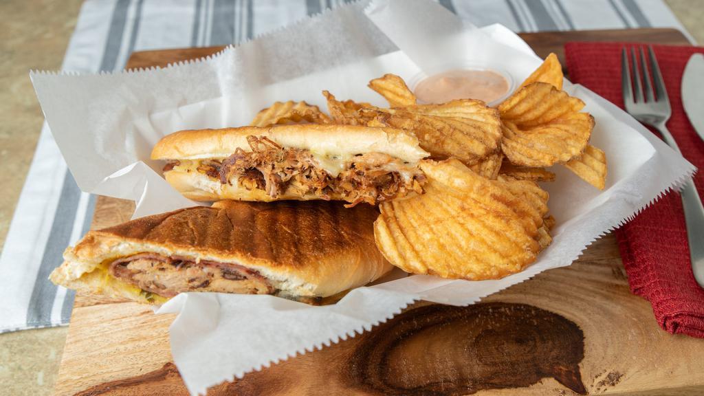 Pressed Cuban Sandwich · Marinated pork, sliced ham, Swiss cheese, pickle chips, and yellow mustard. Served with choice of our homemade chips, French fries, or baked potato salad.