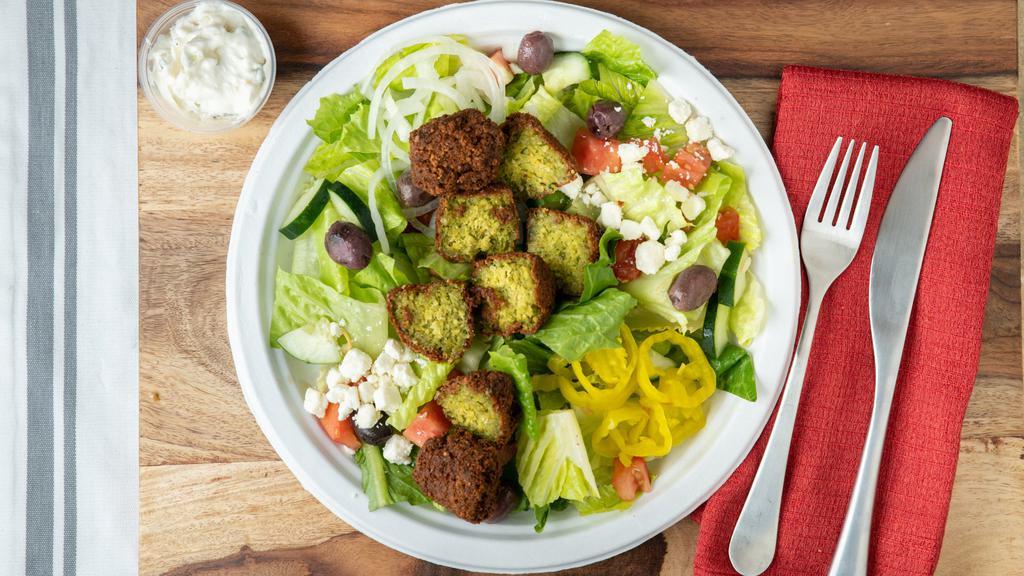 Falafel Salad · Vegetarian. Our homemade falafel served on top of fresh greens, with diced tomatoes, diced cucumbers, kalamata olives, and Feta cheese. Served with our tahini yogurt dressing.