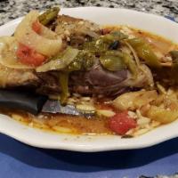 Lamb Shank Exohico · Baked lamb shank with green peppers, onions, tomatoes, and garlic.