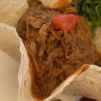 Shredded Beef · Ropa vieja served with three sides.