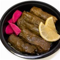 Meat Grape Leaves App · Rolled grape leaves stuffed with ground meat and rice, served with lamb ribs and yogurt.