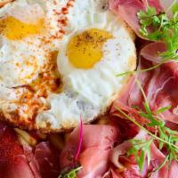 Broken Eggs · Kow version of the Spanish classic huevos rotos. Serrano ham and Italian parsley on a bed of...
