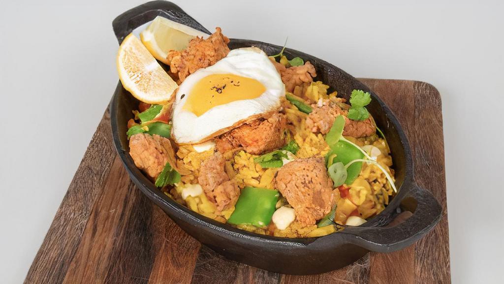 Arroz Con Pollo · Venezuelan style creamy rice with fried and grilled chicken, fried egg, and green peas.