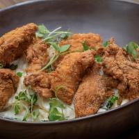 Kow Style Pasta Alfredo · Linguini with heavy cream and parmesan sauce, topped with fried chicken tenders and greens.