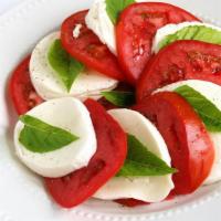 Caprese Salad · Fresh tomato and fresh mozzarella slices, basil and olive oil over romaine lettuce.