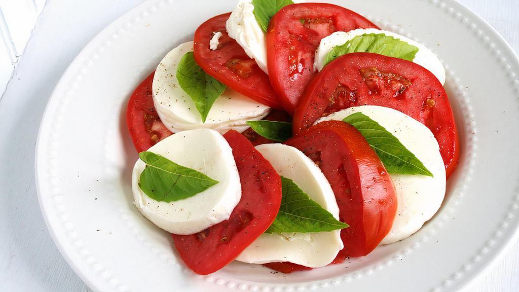 Caprese Salad · Fresh tomato and fresh mozzarella slices, basil and olive oil over romaine lettuce.