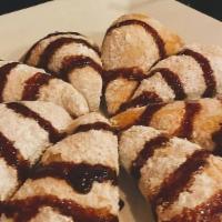 Zeppoles · Deep fried dough ball topped with powdered sugar and cinnamon, finished with chocolate syrup.