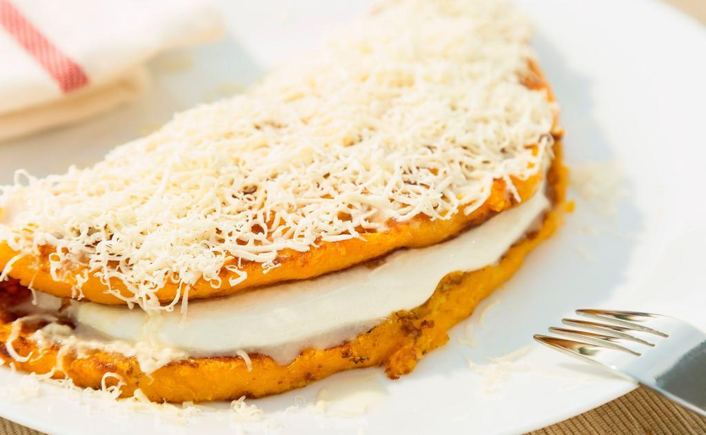 Cachapa De Pollo (Chicken Sweet Corn Cake) · Cachapa de pollo y queso de mano con queso rayado on top