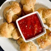 Garlic Knots · Six garlic knots covered in parmesan butter and served with homemade marinara.