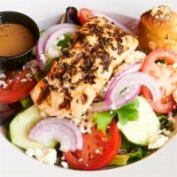 Salmon On The Green · Salmon crusted in peppercorn and seared, served on top of mixed greens, fresh tomatoes cucum...