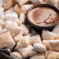 Zeppole · Bite-sized pieces of crispy dough tossed in powdered sugar & paired with rich Nutella hazeln...