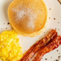 Pancakes Breakfast · With scrambled eggs, and bacon, drizzled with maple syrup.
