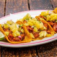 Al Pastor Tacos · Three tacos with marinated pork shoulder, onion, cilantro, pineapple-serrano salsa, corn tor...