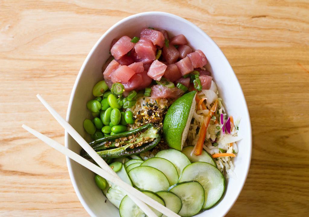 Tuna Poke Bowl · Sushi grade tuna, rice, edamame, cucumber, Asian slaw, and soy sesame vinaigrette topped with furikake and a grilled jalapeno.