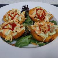 Chicken Tostones · Green plantains basket with chicken, cheese, pink sauce, green sauce (garlic) and ketchup.
