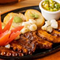 Pulpo A La Parrilla · Grilled octopus tentacles marinated in aji panca served with potatoes, peruvian corn and chi...