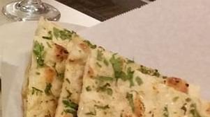 Garlic Naan · Unleavened bread topped with garlic baked in a tandoor