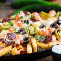 Extreme Loaded Texas Fries · Cheddar cheese sauce, Monterrey Jack cheese, bacon, jalapeños, scallions.
