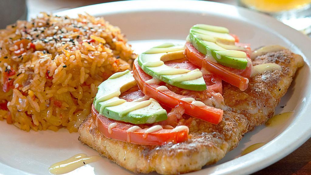 Boca Style Grouper · Grouper filet breaded and pan-sautéed topped with sliced avocado and tomato garnished with a key lime drizzle. Served with tropical fried rice. (Contains Almonds)