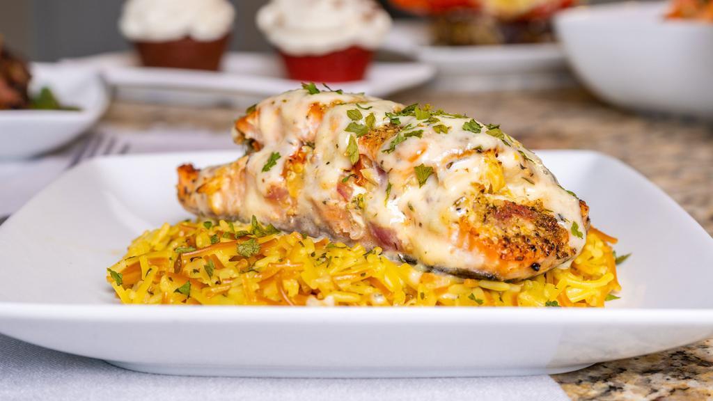 Seafood Stuffed Salmon · Fresh Salmon stuffed with shrimp, lump crabmeat, Tuscan cheese and smoked. Served over a bed of yellow rice, and steamed Veggies.