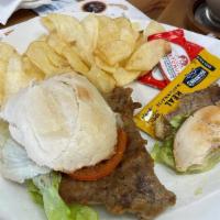 Milanesa · Breaded steak on a toasted baguette, with lettuce and tomatoes.