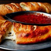 Calzone · Ricotta and mozzarella cheese, spices, fresh garlic baked in pizza dough, brushed with garli...