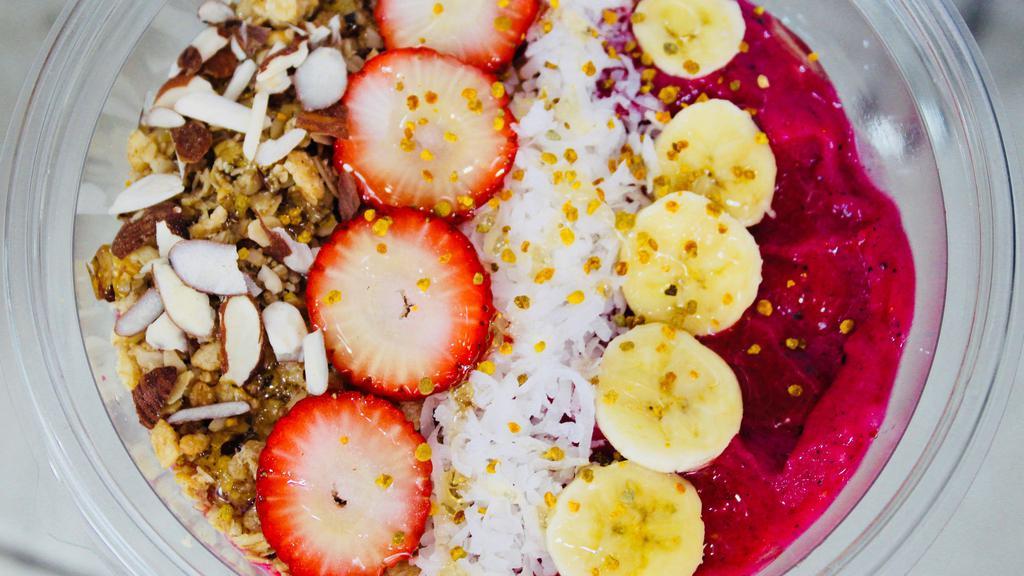 Dragon Heart · Base of the bowl with strawberry pineapple banana dragon fruit and almond milk. on top with granola coconut shaves banana strawberry raw honey bee pollen and almond chips.