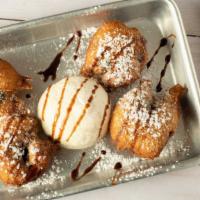 Fried Oreos · battered and fried oreos garnished with powdered sugar and chocolate syrup.