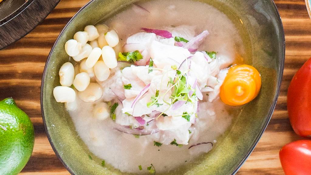 Tradicional Ceviche · Marinated lightly in lime juice and seasoned with Peruvian limo chili, fresh cilantro, and onion, garnished with sweet potato, and choclo (Peruvian giant corn).