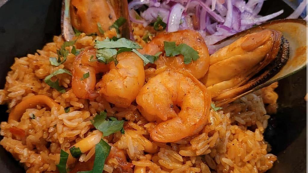 Arroz Con Mariscos · Our best seafood combination of shrimp, squid and scallops, all mixed with rice, red pepper, cilantro, and Peruvian.