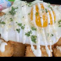 Truffle Tots · Truffle seasoned tater tots with a fried egg and topped with housemade lemon aioli and parme...