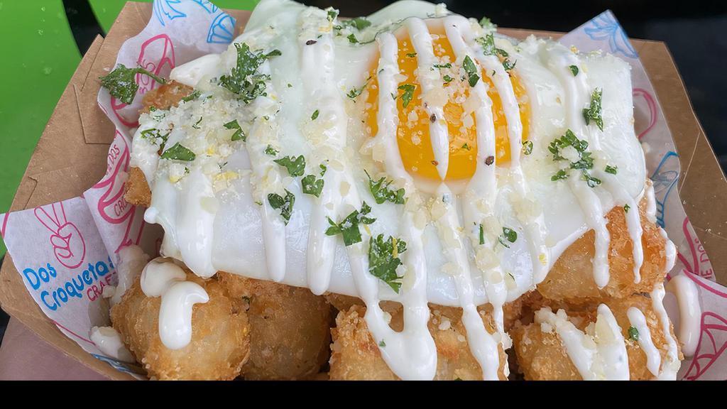 Truffle Tots · Truffle seasoned tater tots with a fried egg and topped with housemade lemon aioli and parmesan parsley with lemon zest