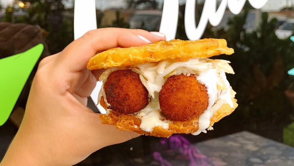 Toston Preparada · Two Crispy Toston buns, your choice of our signature croqueta, shredded cheese, special seasoning, house made sauce topped with papitas.