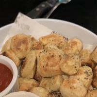 Garlic Bites · Long cook time! Please allow 15 minutes. Fresh dough knots brushed with garlic butter, grate...