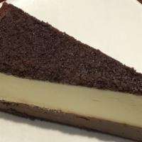 Chocolate Ganache Cheesecake · New york style cheesecake topped with a thick, rich layer of chocolate ganache, sits on a ch...