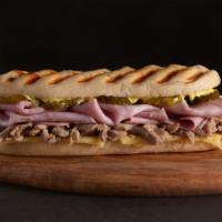 The Cuban · Tender roasted pork and ham served between sliced baguette with a traditional may spread, di...