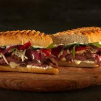 Rib Eye Truffle Sandwich · Panini baguette with Swiss cheese, truffle mayo, sauteed beef shaved steak, garnished with b...