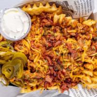 Chili Cheese Fries, · Waffle fries topped with chilli, shredded cheddar
cheese, sour cream, bacon and jalapeno.