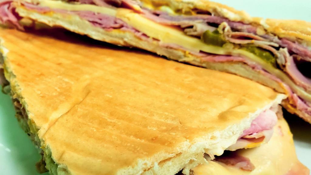 Cubano Sandwich · Buttered cuban bread toasted with serrano ham pressed leg swiss cheese yellow mustard and cucumber