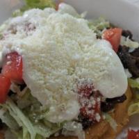 Sope · Homemade corn cope with refried beans, choice of meat, lettuce, tomatoes, sour cream, and co...