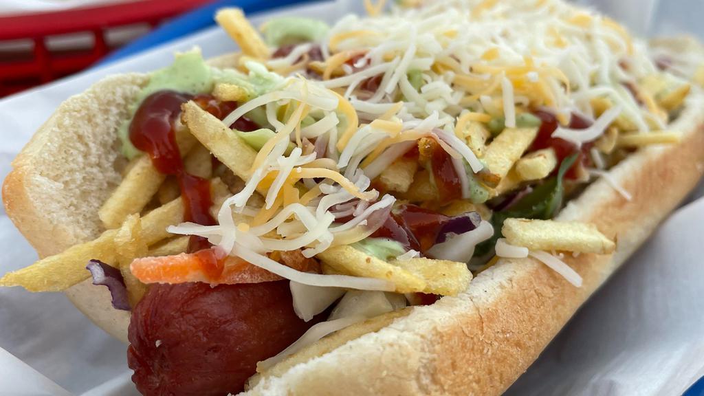 Perro Caliente · Traditional beef frank, shredded cabbage, cheese, and potato sticks with ketchup, mayo, and mustard on a soft bun / Perro de carne tradicional con col rallada, queso, papitas, ketchup, mayonesa y mostaza.