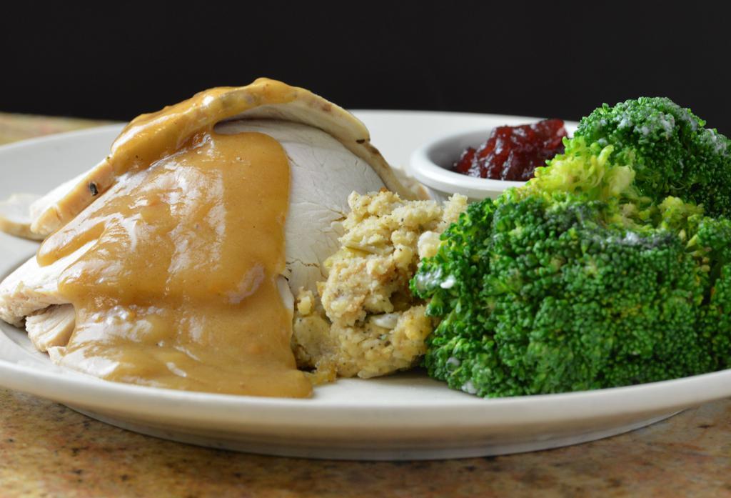 Lch Roasted Turkey & Dressing · Slow roasted, seasoned turkey breast sliced and served over cornbread dressing; finished with our savory turkey gravy, tangy cranberry sauce, and choice of side item