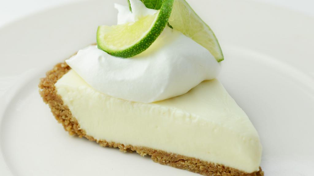 Key Lime Pie · Creamy key lime pie, graham cracker crust, whipped cream, fresh lime