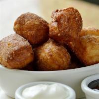Cinnamon Sugar Beignets · Hot, fresh donuts covered in cinnamon sugar, served with chocolate and cream cheese dipping ...